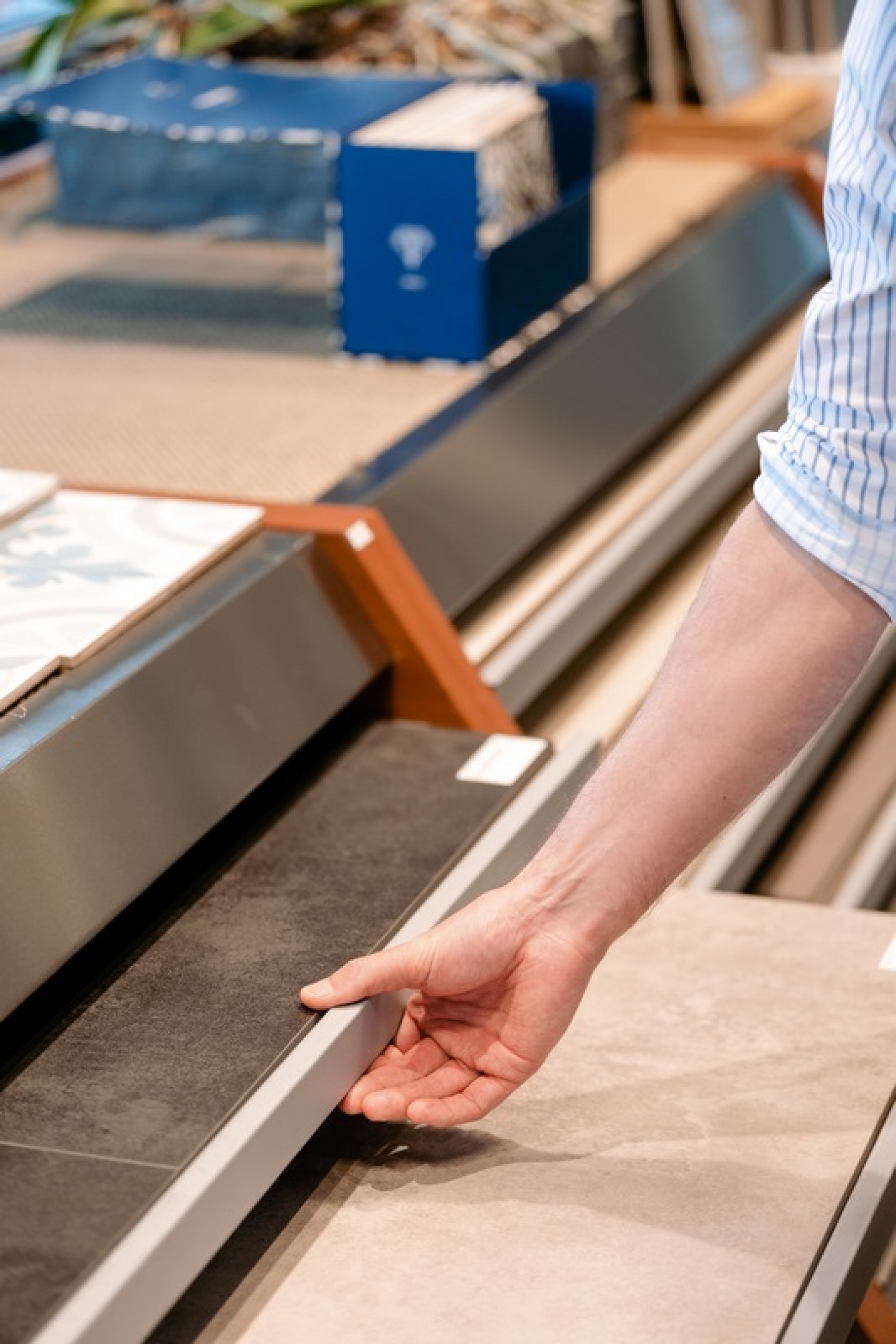 Een klant kiest uit een breed assortiment vloertegels in de toonzaal van Wijckmans.